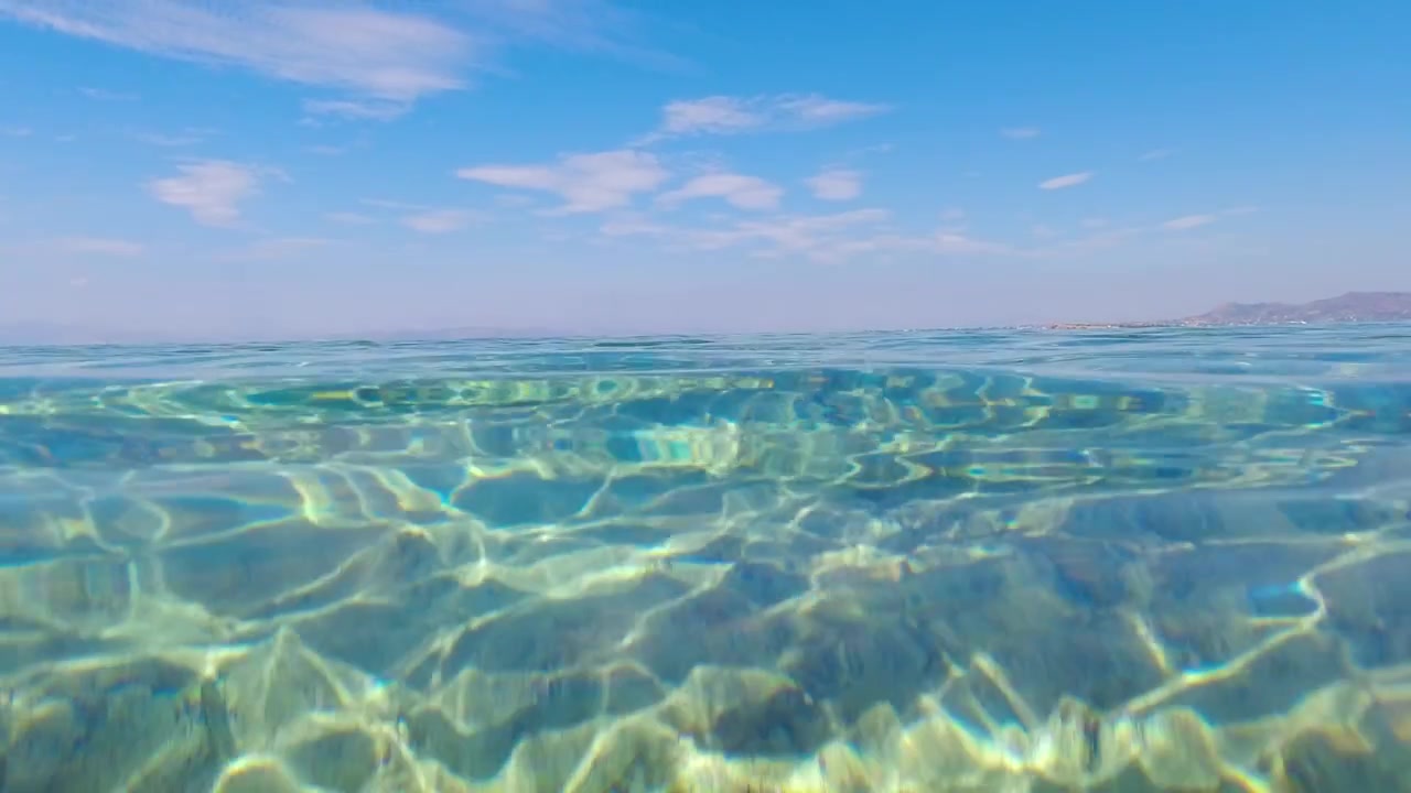 Splendida ripresa che passa da sopra a sotto l'acqua con mare limpido.