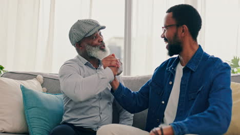 father, son and fun arm wrestling on home sofa