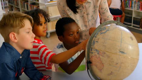 Junge-Asiatische-Lehrerin-Unterrichtet-Die-Kinder-Am-Tisch-In-Der-Schulbibliothek-über-Den-Globus-4k