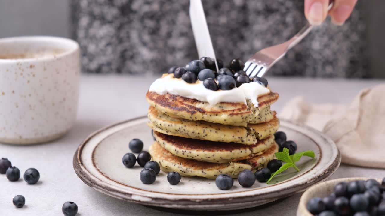 요거트 와 블루베리 를 들인 팬케이크 를 먹는 젊은 여자