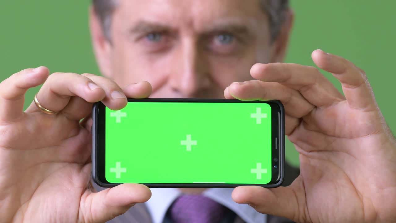 녹색 배경에 성숙한 잘생긴 사업가