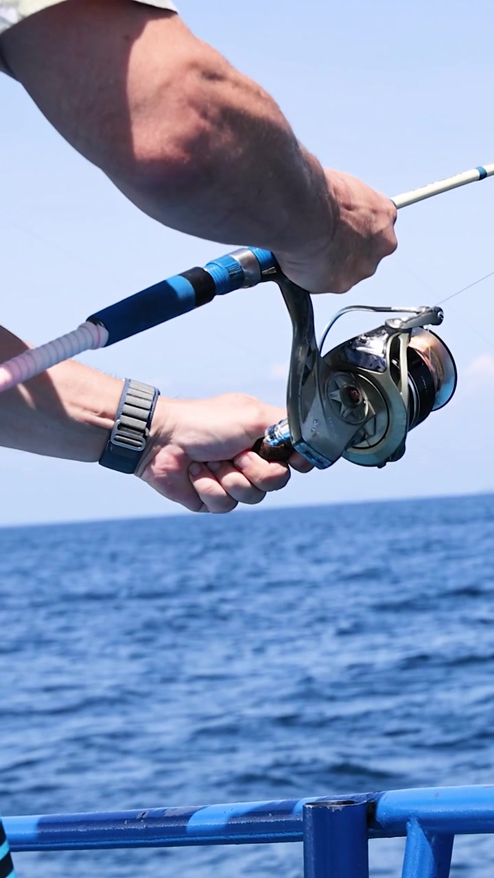 Pescatore recupera il pescato su una barca