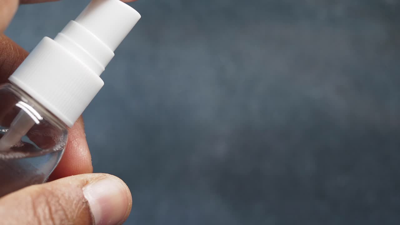 Close-up of a Person Cleaning Eyeglasses with a Spray Bottle