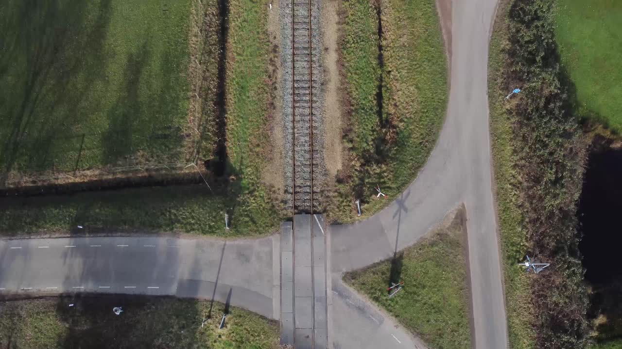 съемка с дрона автомобиля, проезжающего через железнодорожный переезд, с пейзажем