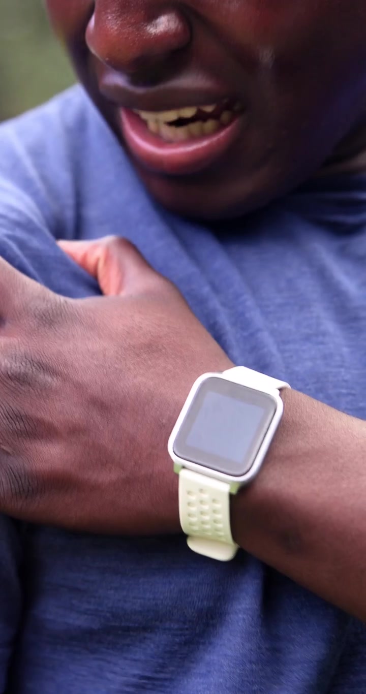 Young Man Checking Smartwatch While Exercising Outdoors