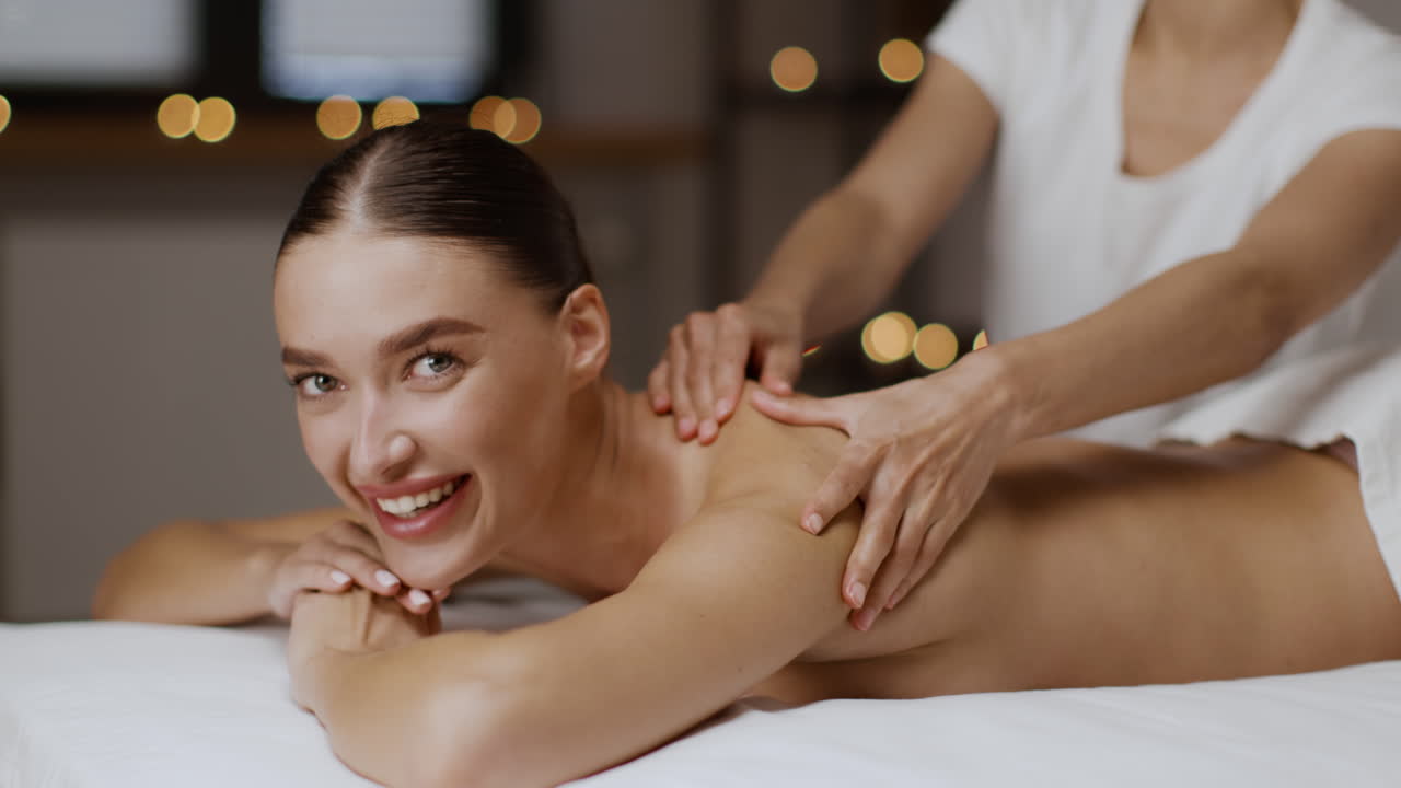 Woman receiving a relaxing shoulder and back massage at a spa