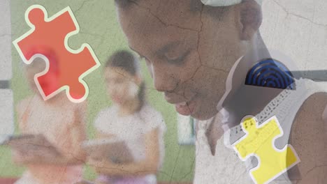 rompecabezas y icono de cabeza humana sobre una niña afroamericana que usa una tableta digital en la escuela