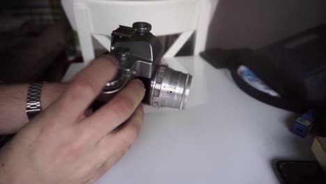 hands winding film roll in retro chrome camera