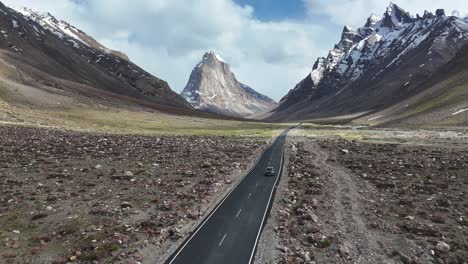aerial drone shot showcasing gumbok rangan’s towering summit framed by dramatic mountain ranges.