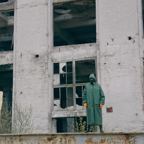 stalker in military protective clothing. lonely human in protective gas mask and military clothes walking on old factory