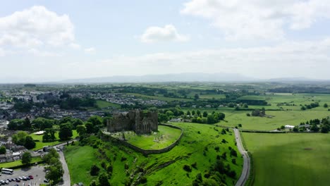 Aerial view pulling away from the Rock of Cashel in Ireland's countryside.