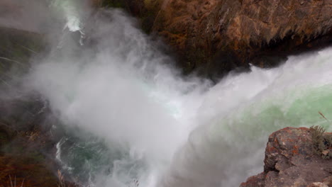toma en ángulo alto de las cataratas superiores de yellowstone con niebla saliendo de la base de las cataratas