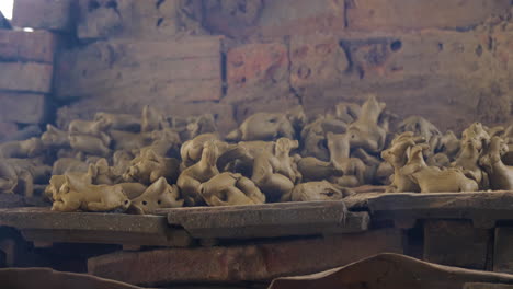 tight view of smoke rising in front of clay figurines getting fired on kiln