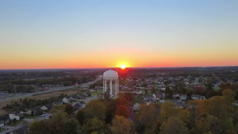 Leuchtend-Orangefarbener-Sonnenuntergang-über-Wohnhäusern-Mit-Wasserturm