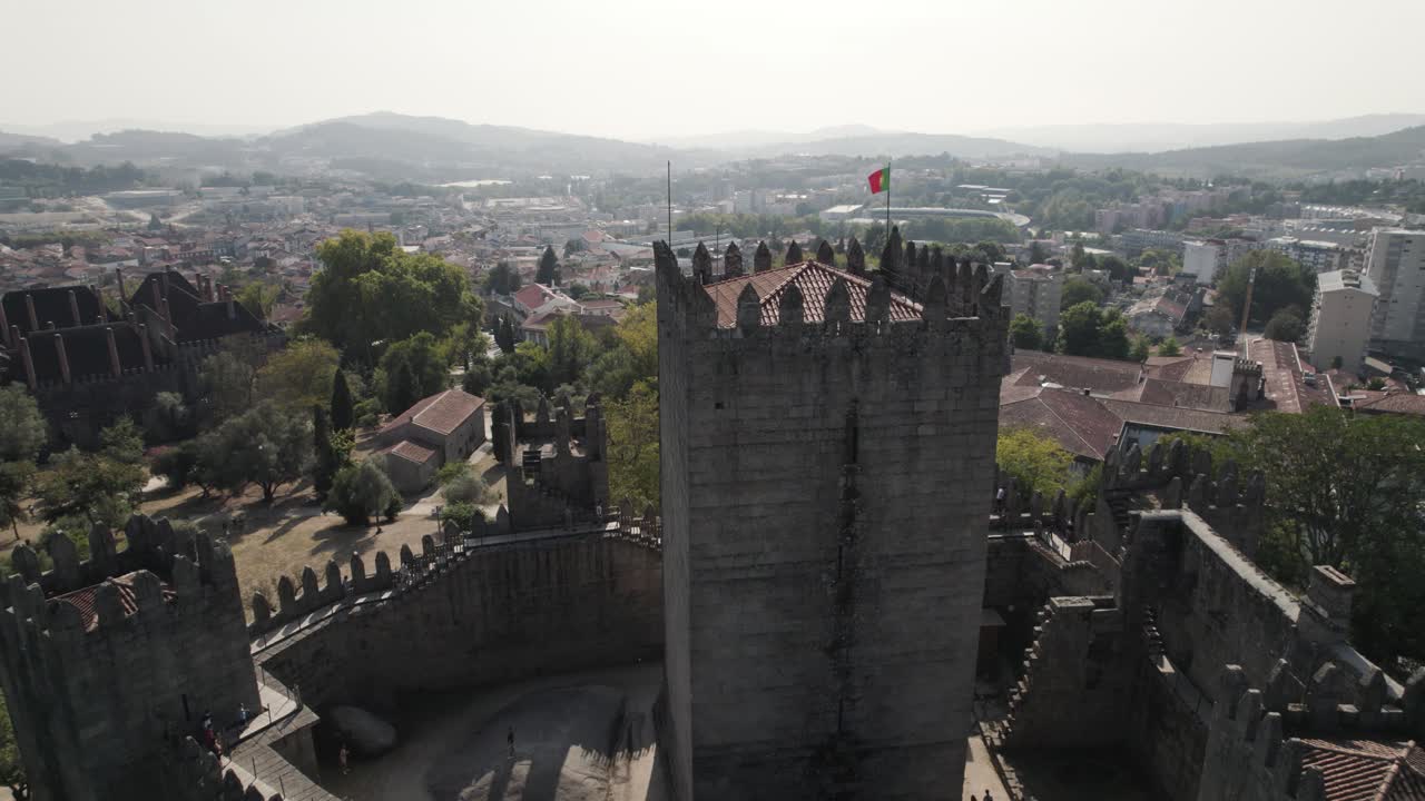 torre en el castillo medieval de guimaraes con orgullosa bandera portuguesa
