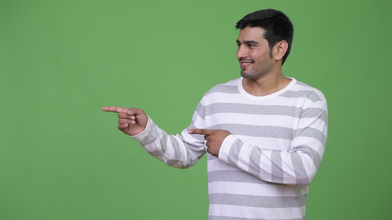 Young handsome Persian man showing something