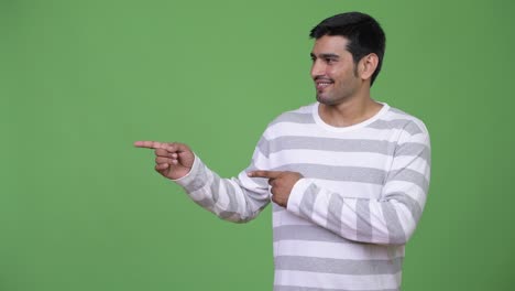 Young handsome Persian man showing something