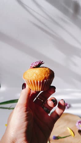 woman holding a decorated cupcake