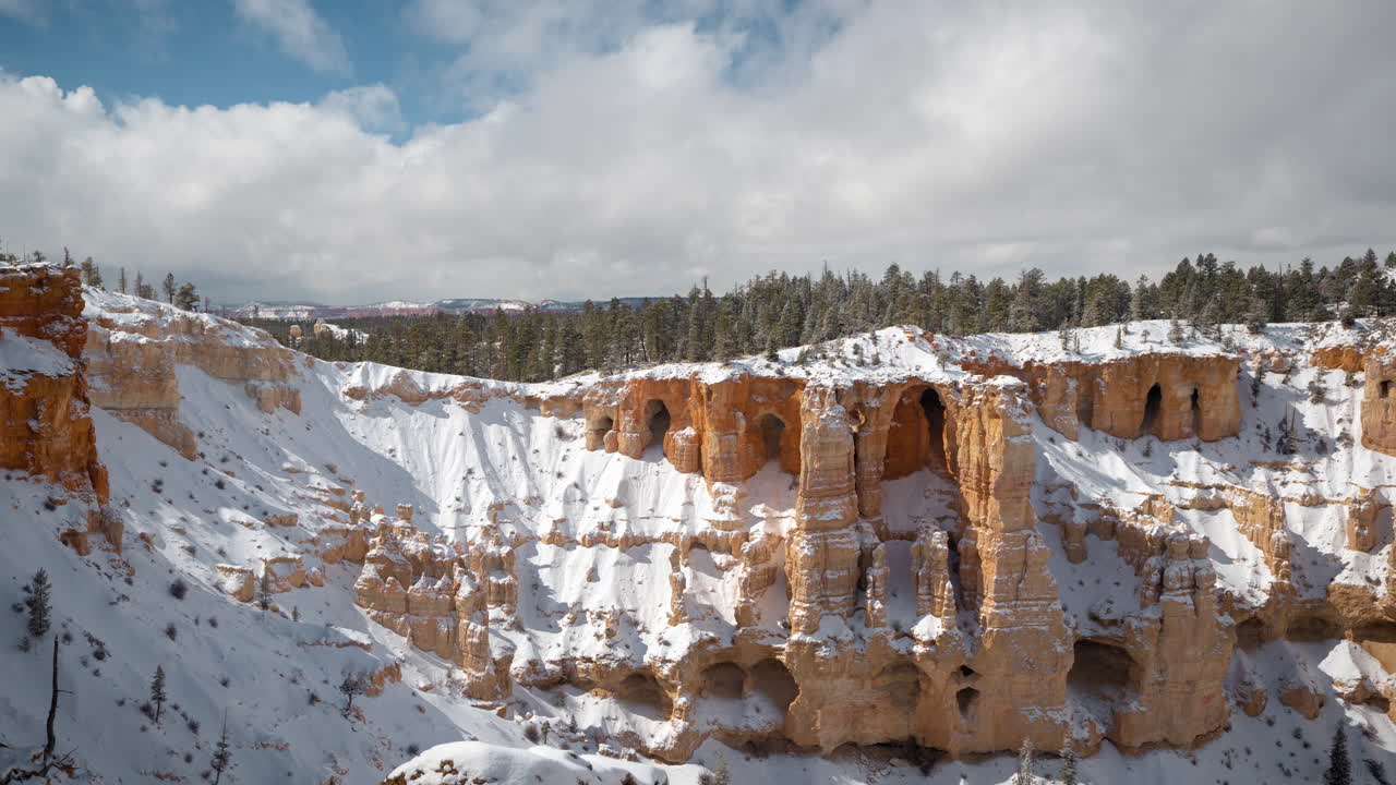 Time-lapse, Bryce Canyon National Park, Utah USA en solig vinterdag, snötäckta röda sandstensklippor och grottor under rörliga moln