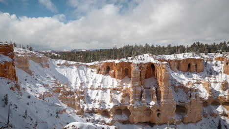 lapso de tiempo, parque nacional bryce canyon, utah usa en un día soleado de invierno, acantilados de arenisca de roca roja cubiertos de nieve y cuevas bajo nubes en movimiento