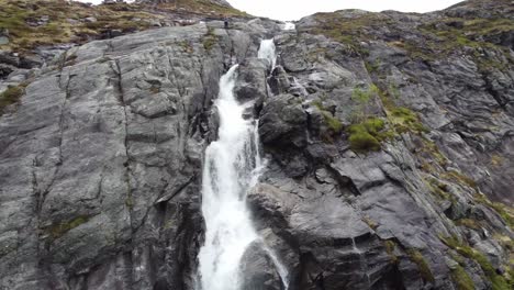 Man-standing-on-edge-of-tall-cliff-where