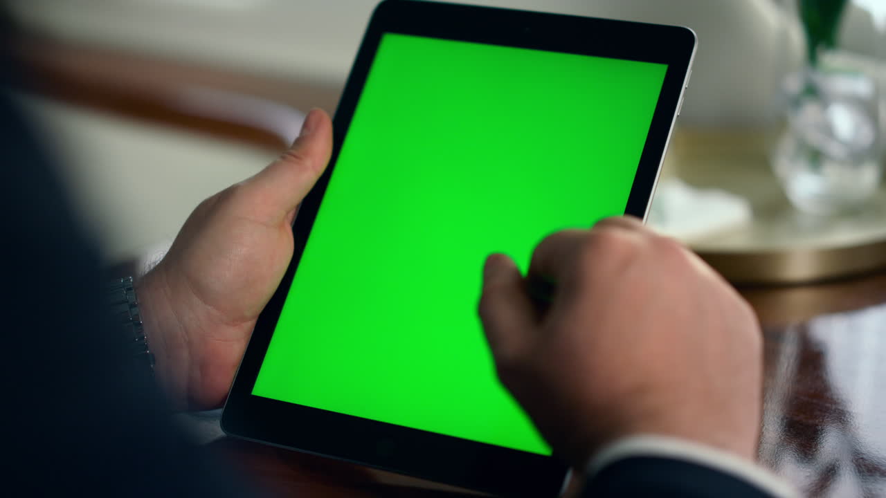gerente deslizando la mano de la pantalla de la tableta verde en primer plano. hombre navegando en maqueta digital