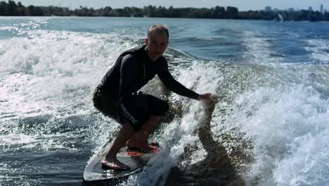 Sportive-man-surfing-on-wakeboard-on-waves-in-slow-motion