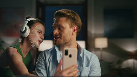 stressed man working laptop at remote workplace. annoying woman making selfie
