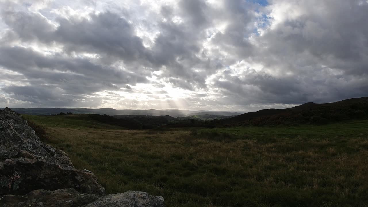 timelapse de rayos de sol moviéndose a través de campo rural inglés tierras de cultivo tempestuoso amanecer