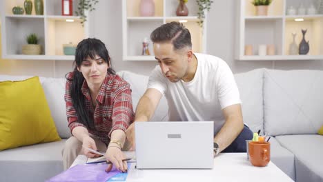 married couple working in home office.