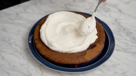 crop cook spreading cream on cake