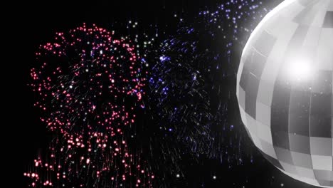 animation of colourful fireworks and rotating mirror ball on black background
