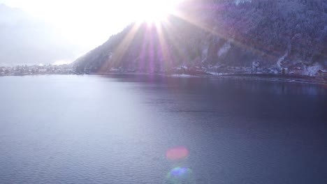 vuelo sobre un lago en las colinas austriacas en invierno y una llamarada solar