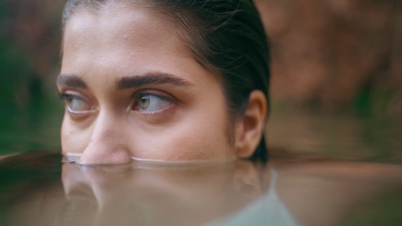 여자의 눈은 호수 표면을 어보고 있습니다. 여름 자연 클로즈업. 명확한 시야 여성 수영