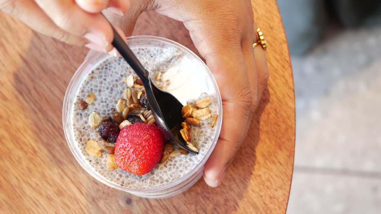 Primo piano di un budino di chia con fragola e granola.