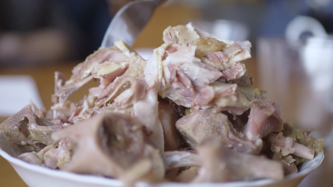 저녁 식사 얕은 포커스를 제공하는 식탁에서 고기 덩어리를 그릇에 담는 사람