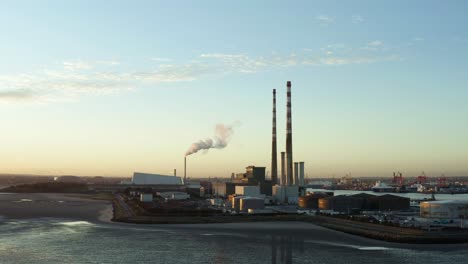 Antena-De-La-Playa-De-Poolbeg-Por-La-Noche,-Planta-De-Energía-En-Segundo-Plano