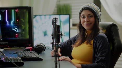 mujer mirando a la cámara sentada frente a una poderosa computadora rgb