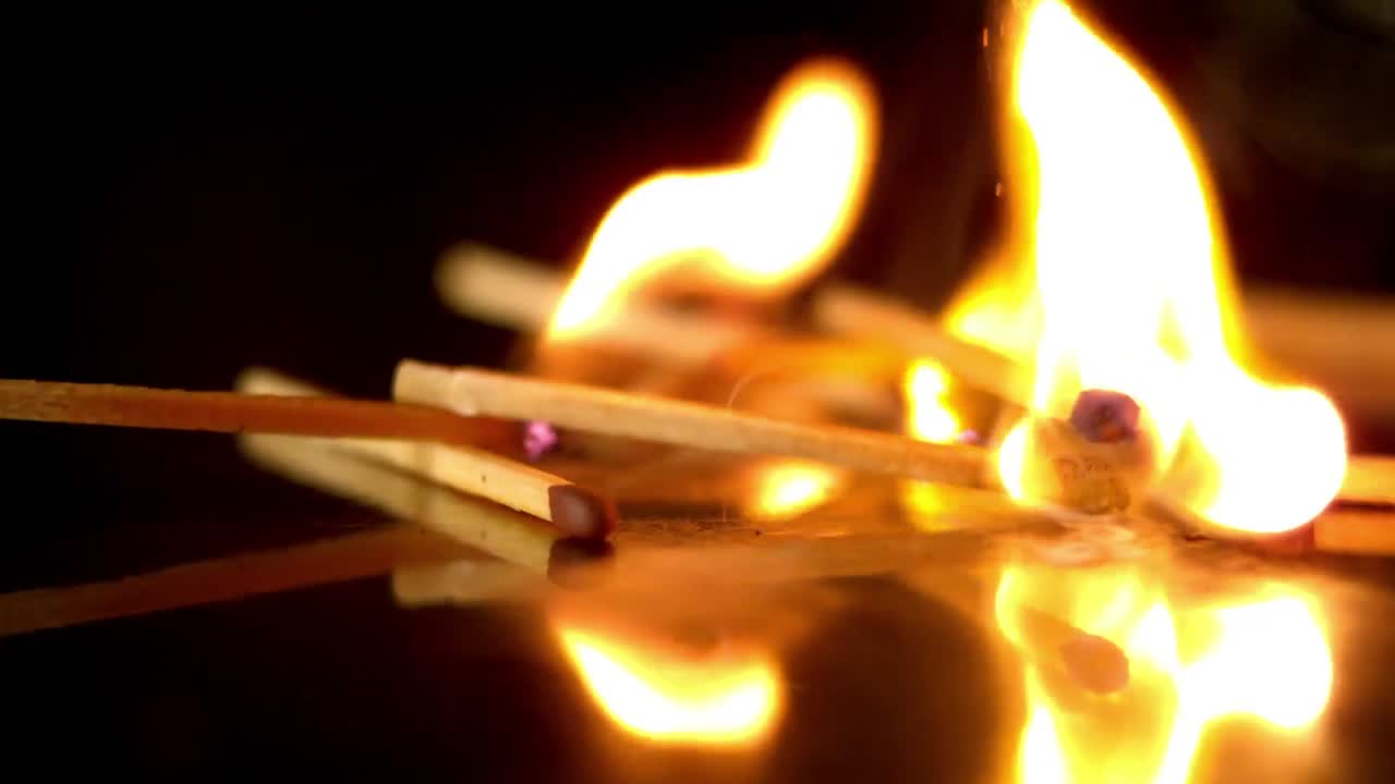 fósforos encendidos cayendo sobre un fondo negro