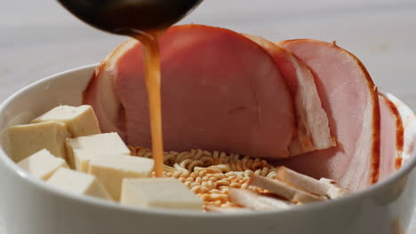 preparando ramen coreano con tofu, jamón y tocino