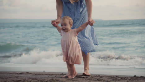 woman walking with child by seashore