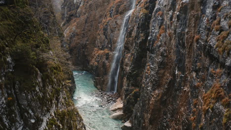 aerial drone view of valle di scalve water cascade streaming down the wet rocky cliff