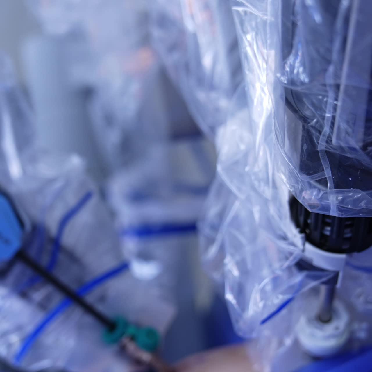 Robotic arms working at operation. Innovative equipment is coated with plastic. Close up