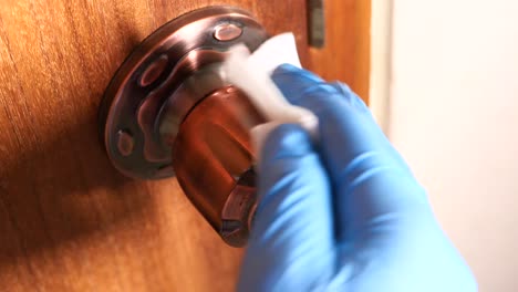 cleaning a door handle with gloves