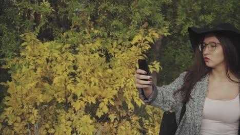 mujer tomando una selfie en el parque de otoño