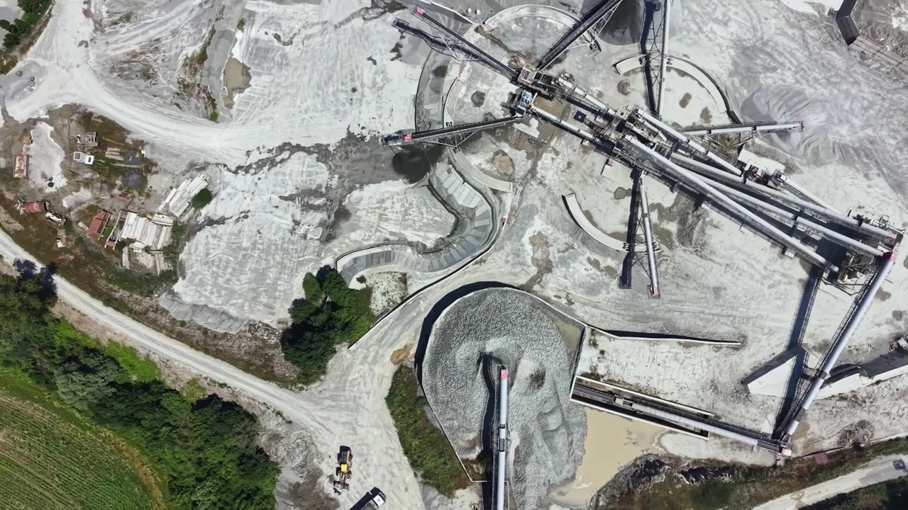 Granite quarry operation with machinery and raw materials during a clear day in a mining location