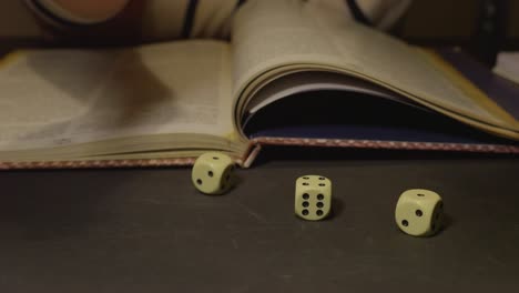 woman hand shaking and rolling six face ivory dices, slow motion