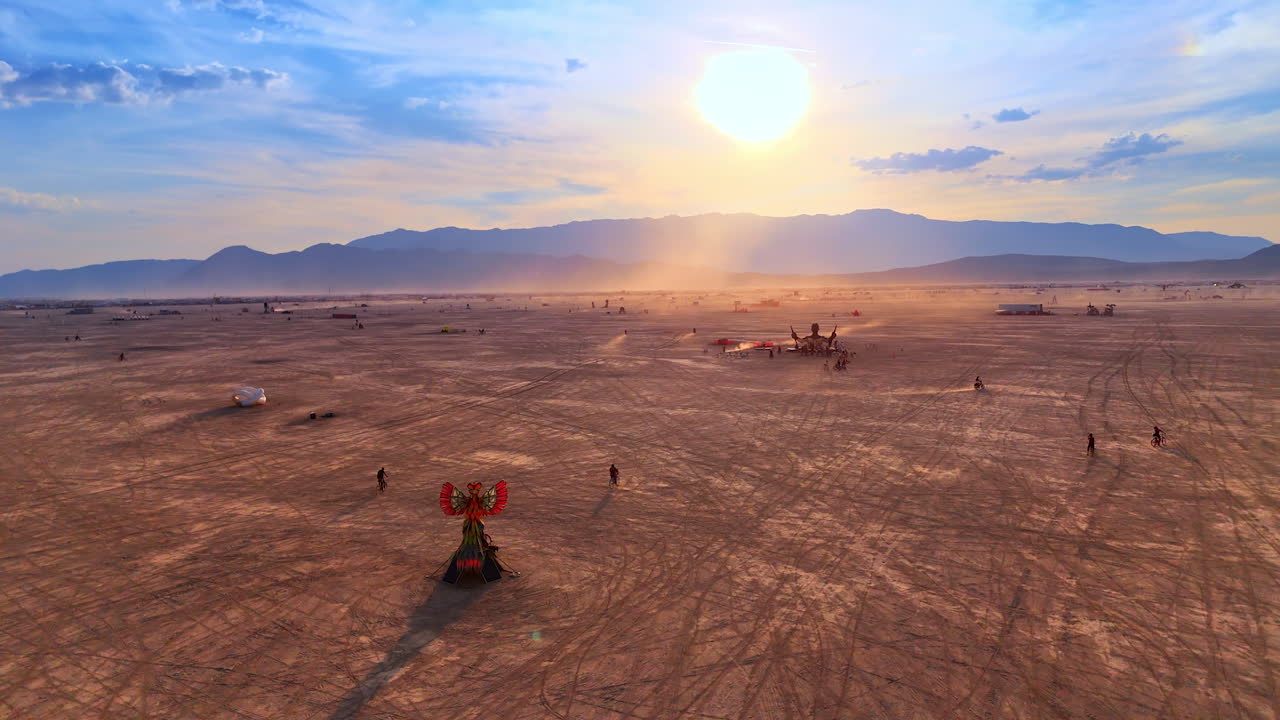 Nevada, USA, 25 August 2025: Aerial drone shot capturing the golden sunset over the Burning Man desert landscape with scattered art pieces and people
