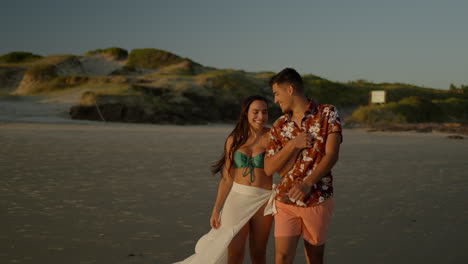 una pareja linda caminando por la playa.