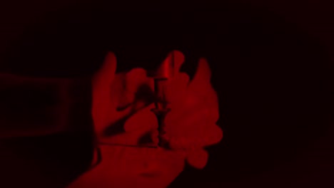 Weibliche-Hände-Zusammengefaltet-Mit-Rotem-Licht-Auf-Schwarzem-Hintergrund